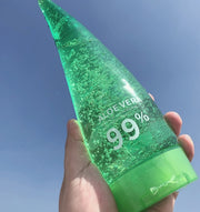 Aloe Gel Skin Care Moisturizing Face Cream bottle with 99% aloe vera, held against a clear blue sky.
