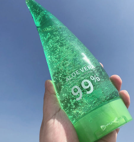 Aloe Gel Skin Care Moisturizing Face Cream bottle with 99% aloe vera, held against a clear blue sky.