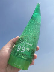 Aloe Gel Skin Care Moisturizing Face Cream bottle with 99% Aloe Vera, hand-held against a clear sky.