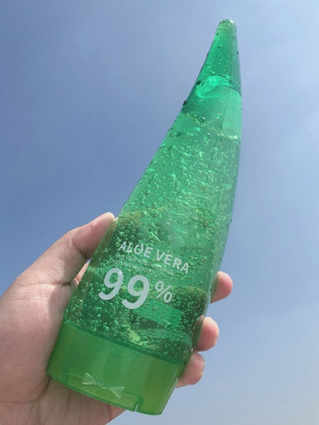 Aloe Gel Skin Care Moisturizing Face Cream bottle with 99% Aloe Vera, hand-held against a clear sky.