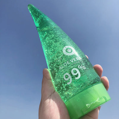 Aloe Gel Skin Care Moisturizing Face Cream in a green tube held against a blue sky, showcasing its 99% aloe vera content.
